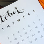 October calendar on top of two pumpkins