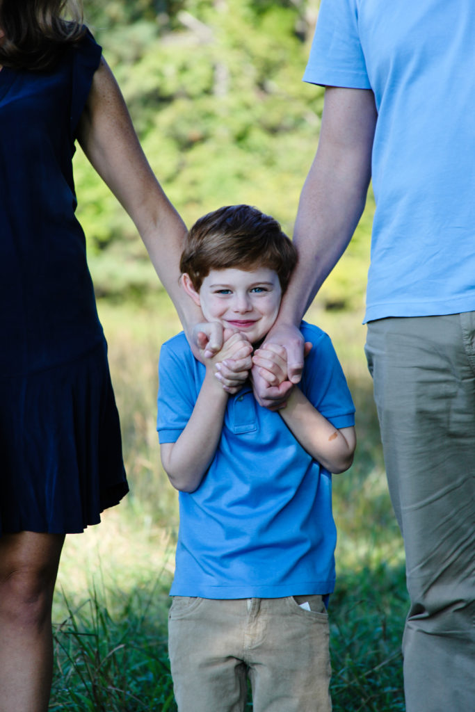 A child with his parents enjoy a family portrait session with Barbara Bell Photography near Chapel Hill, NC.